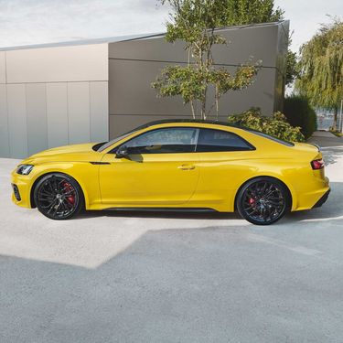 Audi RS5 Coupé желтого цвета сбоку